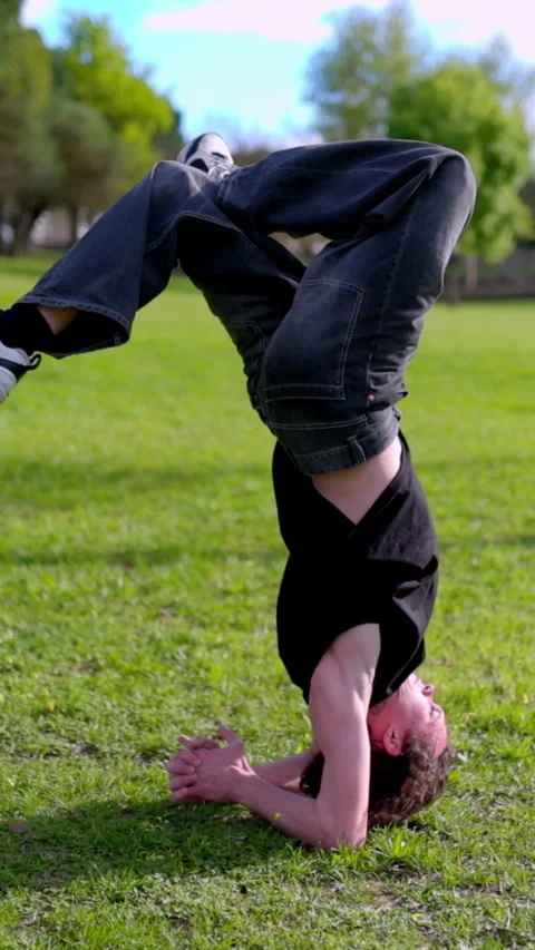 Breakdancer performing headspin and other moves in park Stock Footage 327336080