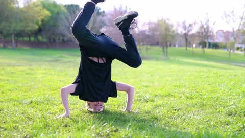 Breakdancer performing headspin in public park Stock Footage 316957951