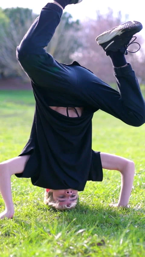 Breakdancer performing headspin in public park Stock Footage 327336035