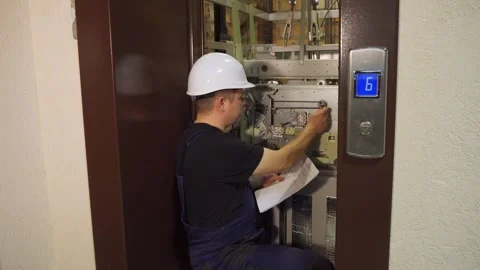 Breakdown in the elevator. Serviceman near an open elevator shaft repairs Stock Footage 265258037