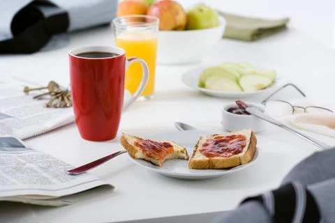 Breakfast and newspaper on table Stock Photos