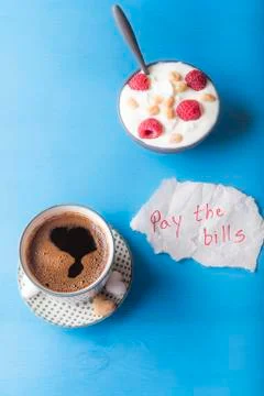 Breakfast and a pay the bills note Stock Photos