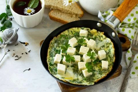Breakfast background. Fried eggs with spinach, feta cheese on stone table. Fotos Stock