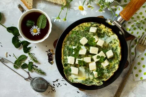 Breakfast background. Fried eggs with spinach, feta cheese on stone table. Stock Photos