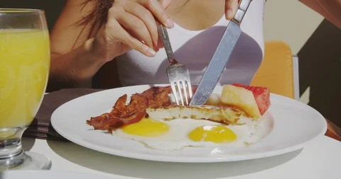 Breakfast with bacon and eggs at restaurant outside with orange juice Stock Footage 114630576