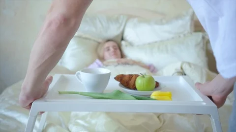 Breakfast in bed, couple on the background out of focus Stock Footage 104461658