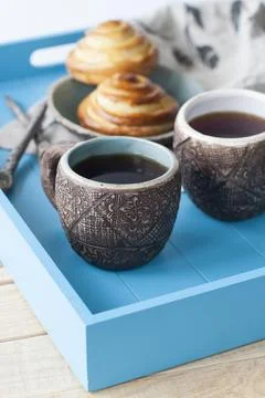 Breakfast in bed: two cups of tea, delicious and hot pastries. Daylight. Stock Photos