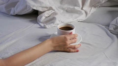 Breakfast in bed. Woman drinking coffee in bed. White linens. Stock Footage 166316902