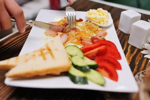 Breakfast - bread and butter on a background of scrambled eggs and bacon with Stock Photos