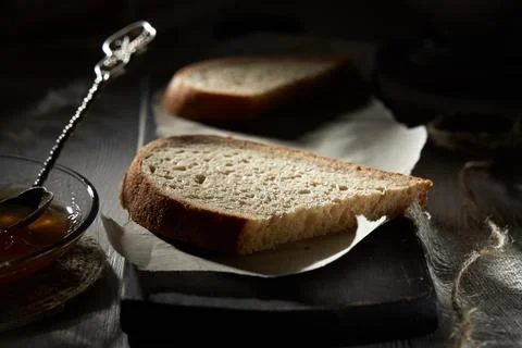 Breakfast with bread and fruit jam on wooden table in the shadow. Stock Photos