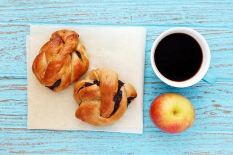 Breakfast with bread roll coffee and apple on baking paper Stock Photos