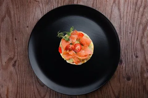 Breakfast, bread toast with scrambled eggs, salmon, avocado and tomatoes Stock Photos