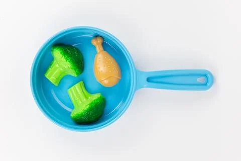 Breakfast with broccoli in a pan on a white background, children's plastic to Stock Photos