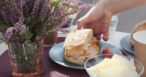 Breakfast brunch, lunch. Hand picking ham turkey sandwich, coffee, latte, melon Video stock 140384790