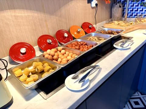 Breakfast Buffet with Eggs, Sausages, Corn, and Bread in Hotel Setting Фото