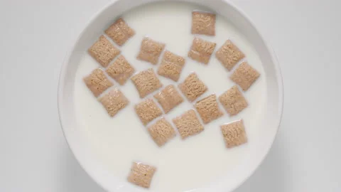 Breakfast cereal bites in a milk in a white bowl, top view Stock Footage 146370023