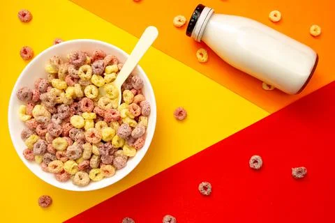 Breakfast cereal concept, Fruit ring cereals in bowl and milk in bottle on co Stock Photos