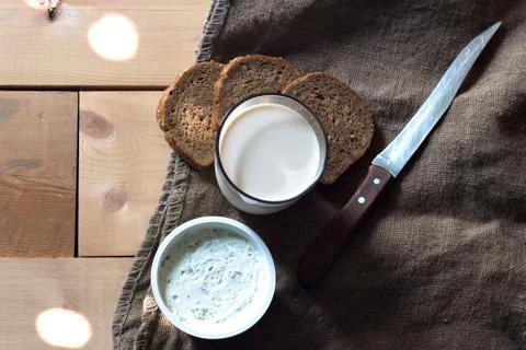 Breakfast of cheese, milk, bread on a light wooden background Foto stock