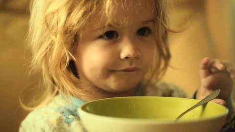 Breakfast child eats. Healthy diet for toddler. Cute boy with beautiful hair Stock Footage 79618860