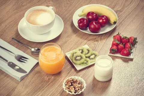 Breakfast with coffee, kiwis, and orange juice on a wooden table Foto stock