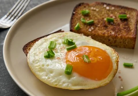 Breakfast Concept. Fried egg and rye fried bread slices, macro Stock Photos