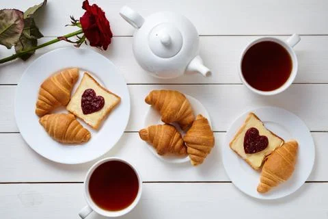 Breakfast for couple on Valentines Day with toasts, heart shaped jam, croissants Stock Photos