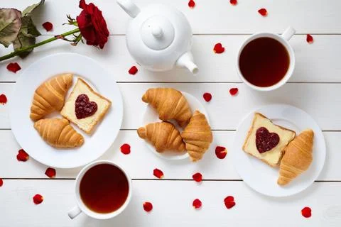Breakfast for couple on Valentines Day with toasts, heart shaped jam, croissants Stock Photos