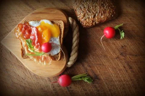 Breakfast , crispy bacon, fried eggs and bread. Sandwich on cutting board. Ru Stock Photos
