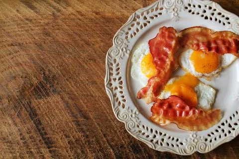 Breakfast , crispy bacon, fried eggs and bread. Sandwiches on white plate. Ru Stock Photos