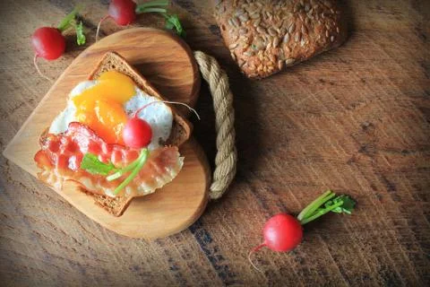 Breakfast , crispy bacon, fried eggs and bread. Sandwich on cutting board. Ru Stock Photos