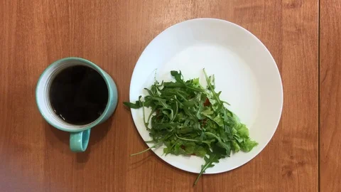Breakfast with a cup of coffee and arugula salad Vídeos de archivo 101124970