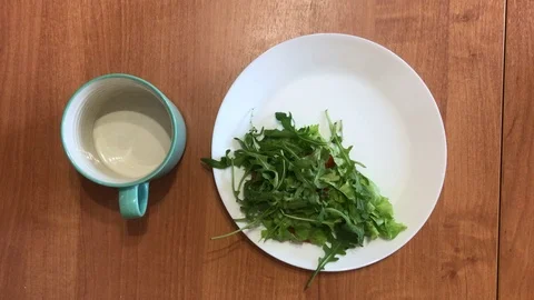 Breakfast with a cup of coffee and arugula salad Vídeos de archivo 101125010