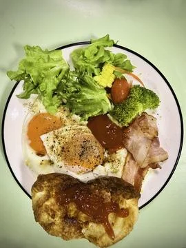 Breakfast dish.there are fried eggs,bread,some vegetable,bacon Фото