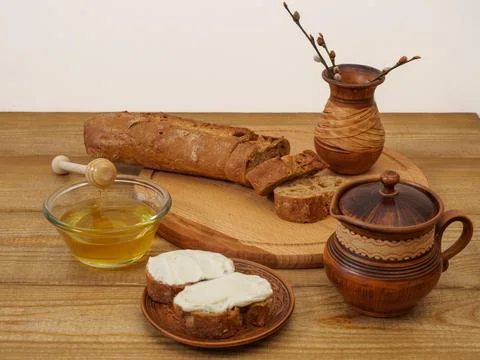 Breakfast in earthenware on a wooden table. Rustic natural products, baguette Stock Photos
