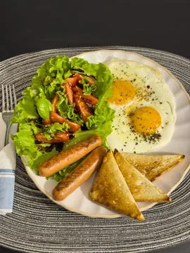 Breakfast eating process sequence from full plate with fried eggs, sausages.. Stock Photos