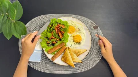Breakfast eating process sequence from full plate with fried eggs, sausages.. Stock Photos