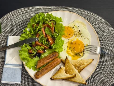 Breakfast eating process sequence from full plate with fried eggs, sausages.. Stock Photos
