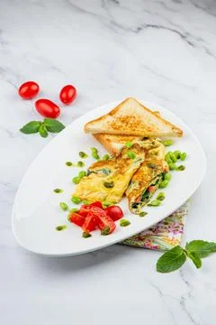 Breakfast of eggs and vegetables with cherry tomatoes and slices of bread in a Stock Photos