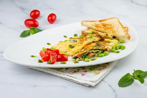 Breakfast of eggs and vegetables with cherry tomatoes and slices of bread in a Stock Photos