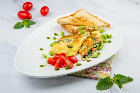 Breakfast of eggs and vegetables with cherry tomatoes and slices of bread in a Stock Photos
