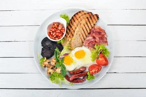 Breakfast. Eggs with bacon and tomatoes, toast bread. Top view. On a wooden b Stock Photos