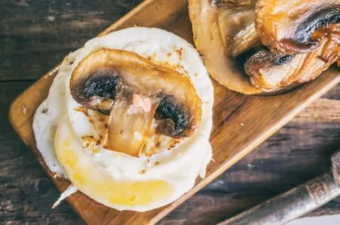 Breakfast eggs Benedict poached egg with pan-fried mushrooms and vegetables. Stock Photos