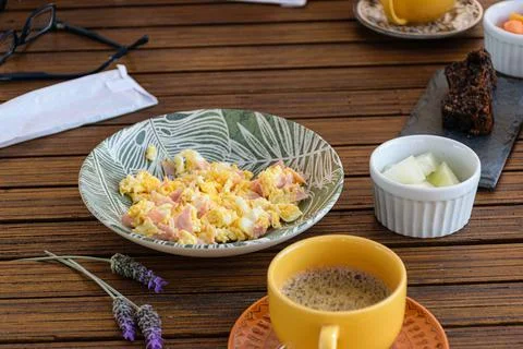Breakfast. Eggs with ham, coffee cup, melon portion, cookie cake and lavender Stock Photos