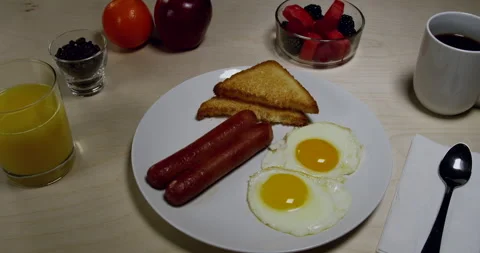 Breakfast Eggs, sausage and some fruit Stock Footage 243405076