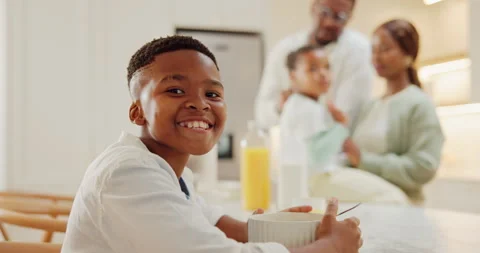 Breakfast, face and smile of black child in kitchen of family home with parents Stock Footage 337541591