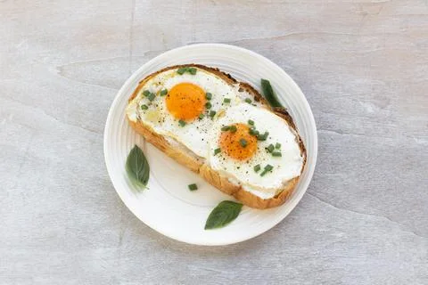 Breakfast food fried egg on bread slice in plate on white wood table Stock Photos