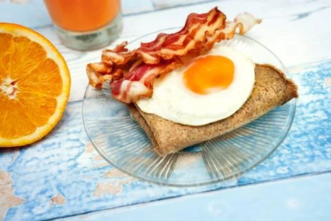 Breakfast with fried egg, bacon and pancake Stock Photos