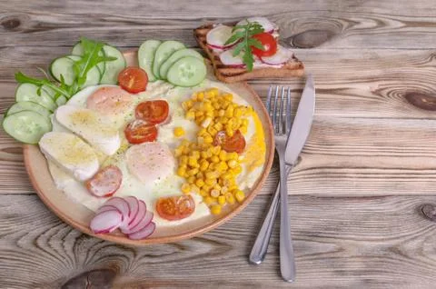 Breakfast. Fried eggs with cherry tomatoes, mozzarella cheese, fresh vegetabl Stock Photos