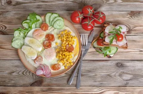 Breakfast. Fried eggs with cherry tomatoes, mozzarella cheese, fresh vegetabl Stock Photos