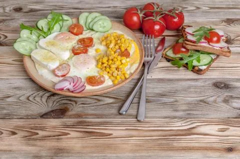 Breakfast. Fried eggs with cherry tomatoes, mozzarella cheese, fresh vegetabl Stock Photos